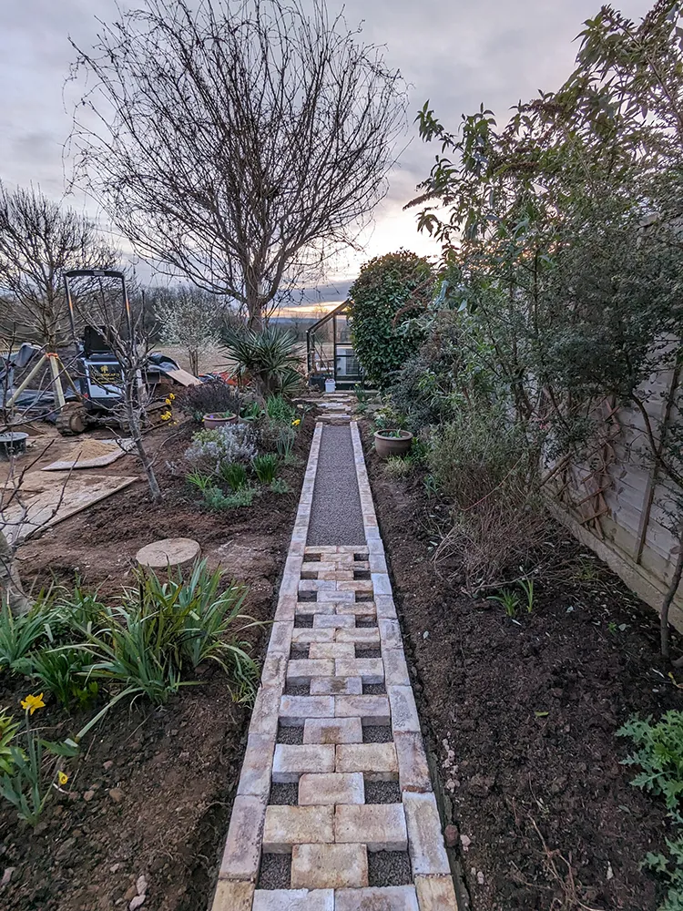 Newly cut path with bricks being laid out