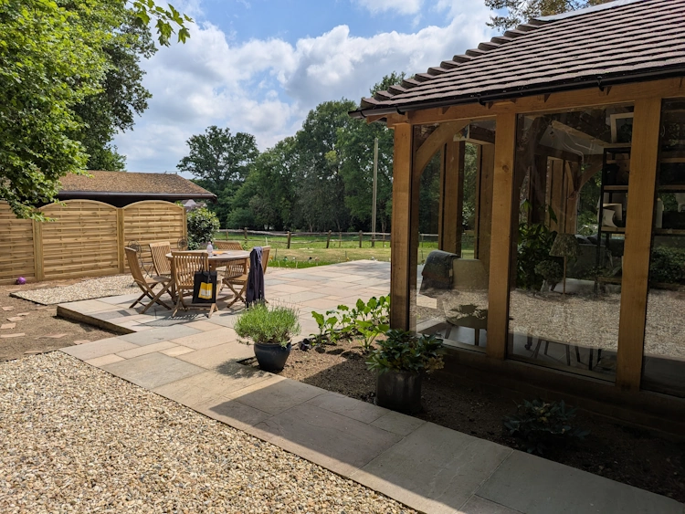 Curved fence panels screening the home office with structure for climbing plants