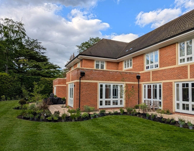 Contemporary house in Weybridge framed by generous borders and a timber pergola