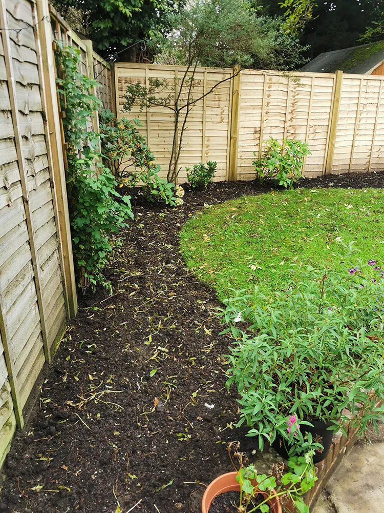 Newly prepared flower beds next to a wall