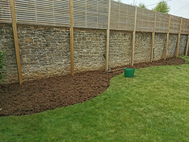 Wall and freshly cut out flower beds